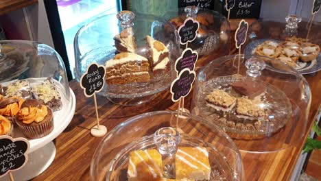 A-beautiful-selection-of-delicious-tasty-homemade-cakes,-cupcakes,-slices-and-other-sugary-treats-displayed-on-counter-of-local-cafe