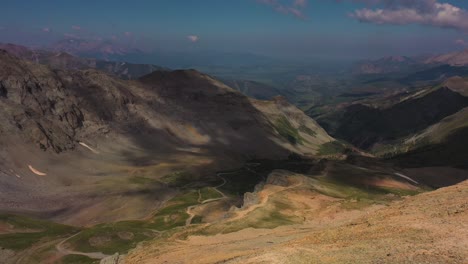 Aerial-overview-of-the-summer-view-from-the-summit-of-Imogene-pass-in-Colorado-featuring-the-beautiful-mountain-range-and-winding-trail-path