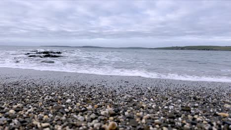 Kiesel-Und-Sand-Mit-Sanften-Wellen,-Die-Ruhe-Eines-Irischen-Strandes
