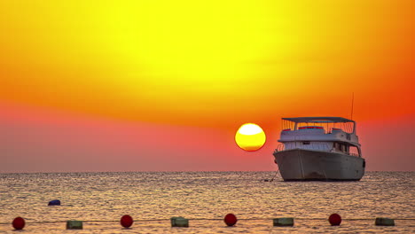 Atemberaubender-Zeitraffer-Eines-Sonnenaufgangs-Am-Horizont-Mit-Einem-Verankerten-Boot-Im-Wasser