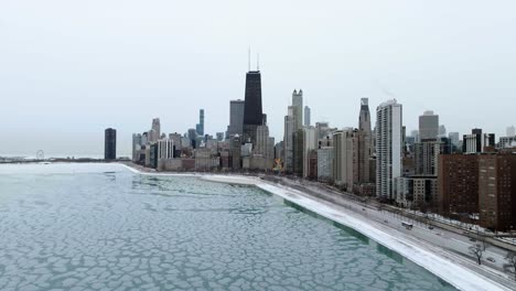 Aerial-view-over-ice,-around-the-Near-North-Side-skyline,-winter-in-Chicago,-USA