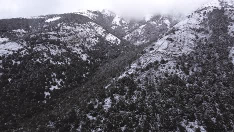 Atemberaubende-Schneebedeckte-Berglandschaft,-Luftfliegen-Schnell-über-Wald,-Tag