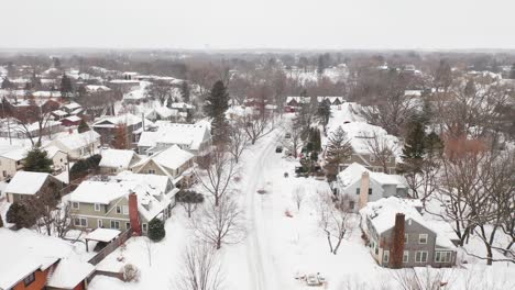 Aerial,-snow-covered-houses-in-suburban-neighborhood-during-winter