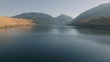 Luftaufnahme-Von-Kajaks-Auf-Einem-Wunderschönen-See-Mit-Bergen-Im-Hintergrund