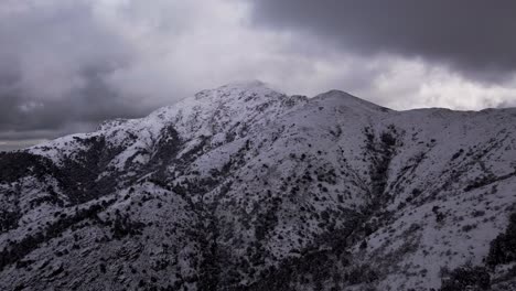 Antena-Del-Pico-De-La-Montaña-Blanca-Nevada-Con-Cielo-Nublado-Dramático,-Adelante,-Día