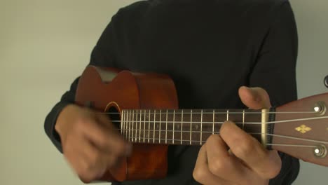 Man-playing-a-Ukelele-with-his-hand