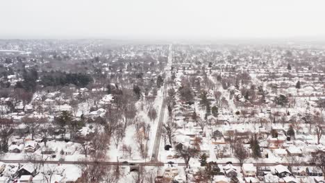 Aerial,-suburb-neighborhood-in-the-United-States,-houses-covered-in-snow-during-winter