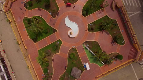 Rising-spinning-drone-shot-over-park-fountain-in-Ecuador-town-center
