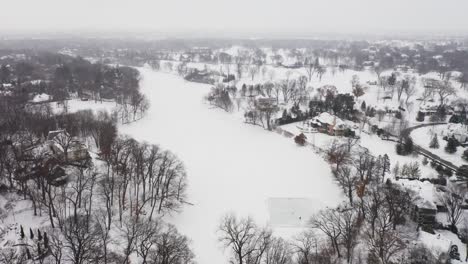 Aerial,-people-skating-on-a-homemade-ice-rink-on-a-frozen-lake