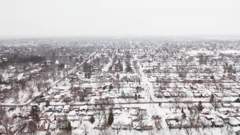 Aerial,-neighborhood-suburb-houses-covered-in-snow-in-the-United-States-during-winter