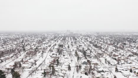 Aerial,-suburb-neighborhood-in-the-United-States-covered-in-snow-during-winter