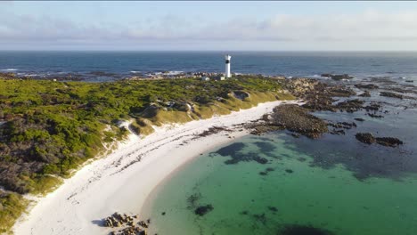 Weißer-Leuchtturm-Und-Vögel,-Die-In-Einer-Geschützten-Bucht-Am-Moonlight-Beach,-Pringle-Bay,-Fliegen