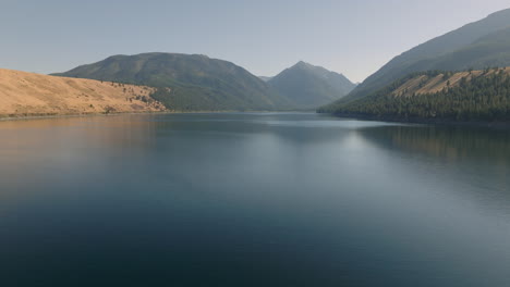 Antenne-über-Dem-Atemberaubenden-Ribbon-Lake-Mit-Dunstigen-Bergen-Im-Hintergrund