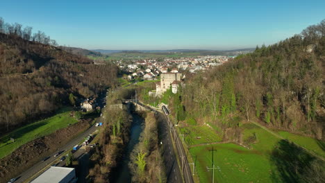 Beautiful-historical-Schloss-Angenstein-builded-on-a-hill-while-a-train-is-driving-through-the-tunnel-with-a-great-view-on-the-river-Bird-and-city-Aesch