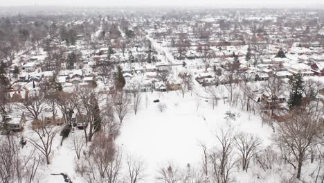 Aerial,-neighborhood-suburb-in-rural-America,-houses-covered-in-snow-during-winter