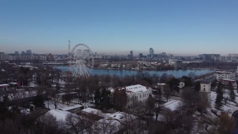Aerial-Of-Ferris-Wheel,-Park-And-A-Lake-At-Winter