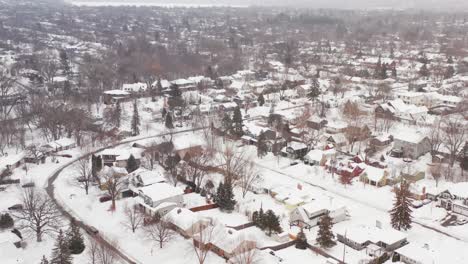 Aerial,-snow-covered-houses-in-rural-small-town-neighborhood-suburb-during-winter