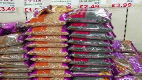 London,-England---July-09-2019:-Dolly-shot-of-various-lentils,-beans-and-pulses-typically-used-in-South-Asian-cooking,-in-a-food-store-in-Southall,-West-London