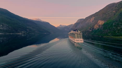Aerial-view-of-gigantic-cruiser-ship-on-tranquil-Fjord-between-mountains-of-Norway-in-the-morning---wide-shot