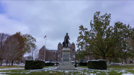 Timelapse-of-the-statue-in-front-of-the-Ontario-Legislative-Building-in-Toronto-with-looming-stormy,-overcast-sky-behind