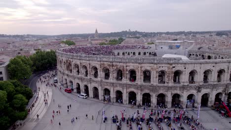 Aerial-view-shot-of-the-Arenas-de-Nîmes-during-the-day-of-people-queuing-to-return