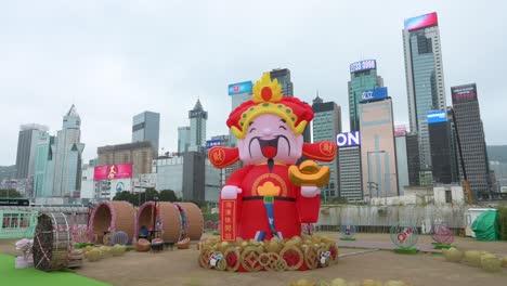 Eine-Frau-Fotografiert-Eine-Outdoor-veranstaltung-Zum-Chinesischen-Neujahrsthema-Zum-Chinesischen-Neujahrsfest,-Während-Im-Hintergrund-In-Hongkong-Wolkenkratzer-Zu-Sehen-Sind