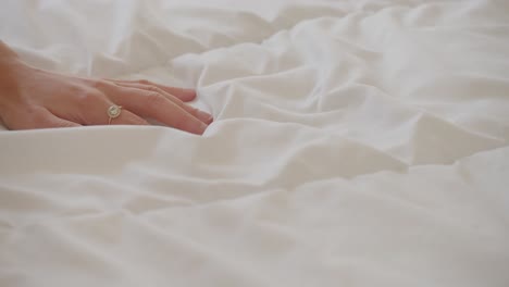 Hand-Der-Frau,-Die-Weiche-Weiße-Bettdecke-Berührt