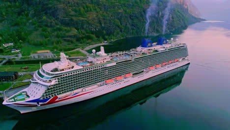 Aerial-birds-eye-shot-of-giant-Cruise-Ship-at-Port-of-Flam-with-rising-smoke-of-stacks-in-Norway,Europe