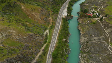 Highway-next-to-turquoise-water-river,-bike-track-alongside-road