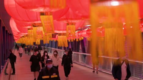 Commuters-are-seen-walking-through-a-pedestrian-bridge-decorated-with-Chinese-red-lanterns-hanging-from-the-ceiling-to-celebrate-the-Chinese-Lunar-New-Year-festival-in-Hong-Kong