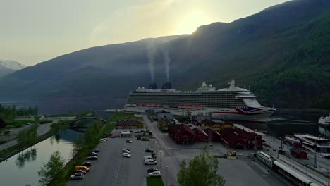 Aerial-flight-towards-docking-large-cruise-ship-after-arrival-at-Flam-Port-in-the-evening---Fumes-of-funnel-rising-up-to-sky