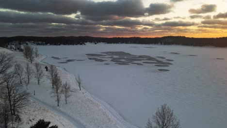 Steigt-Auf-Und-Dreht-Sich-Bei-Sonnenuntergang-Zu-Einem-Zugefrorenen-See