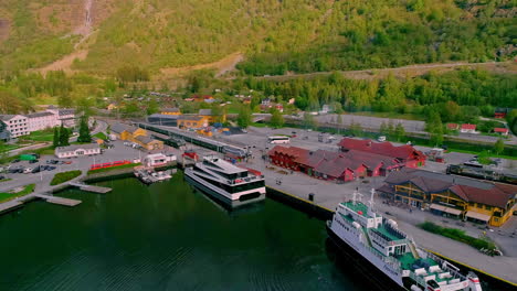 Aerial-backwards-shot-of-ferry-and-industrial-boat-at-port-of-Flam-in-Norway