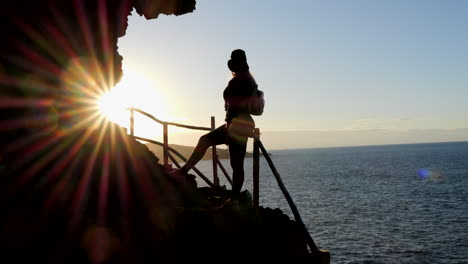 Fantastische-Aufnahme-Einer-Jungen-Frau-Mit-Hut,-Die-Während-Des-Sonnenuntergangs-Die-Landschaft-An-Der-Küste-Der-Gemeinde-Galdar-Auf-Der-Insel-Gran-Canaria-Und-Während-Des-Sonnenuntergangs-Bewundert