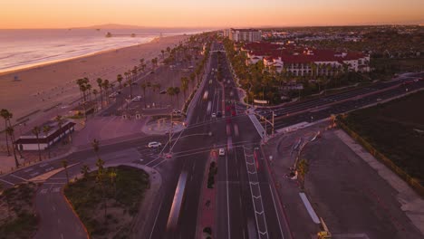 rush-hour-hustle-and-bustle-at-the-intersection-of-Beach-Boulevard-and-Pacific-Coast-Highway-in-this-vibrant-drone-time-lapse,-showcasing-the-changing-colors-at-sunset-head-on-view
