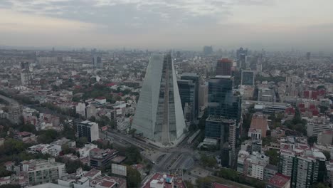 Aerial-orbit-view-of-huge-buildings-on-cloudy-day-in-Mexico-City---slow-motion