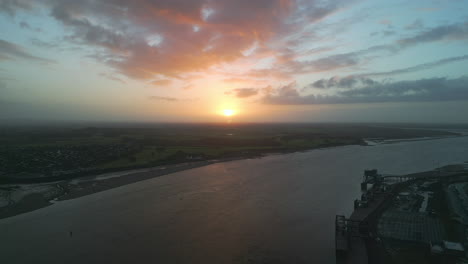 Slow-motion-river-at-sunrise-with-pan-down-to-disused-dockland-of-fishing-port-Fleetwood