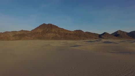 Death-Valley-California-sand-dunes-mountains-souring-fly-over-slow-pull-back-Drone-4k-Establishing-shot