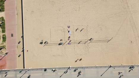 Sehenswürdigkeiten-Von-Huntington-Beach-Mit-Diesem-Fesselnden-Drohnen-Zeitraffer,-Der-Strandbesucher-Zeigt,-Die-Volleyball-Spielen-Und-Auf-Der-Promenade-Und-Dem-Pier-Spazieren-Gehen