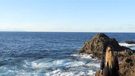 Aufnahme-Einer-Frau,-Die-Die-Wellen-Des-Meeres-Bewundert,-Die-An-Der-Küste-Der-Gemeinde-Galdar,-Auf-Der-Insel-Gran-Canaria-Und-Während-Des-Sonnenuntergangs-Zu-Finden-Sind