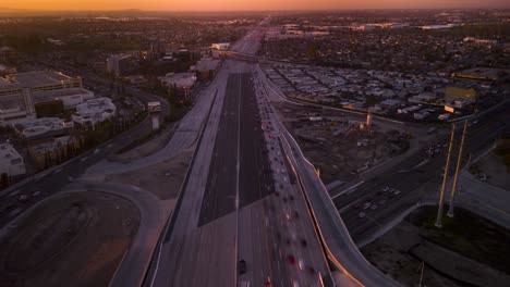Impresionante-Hiperlapso-De-Drones-Captura-El-Tráfico-De-La-Hora-Pico-De-La-Autopista-405-Y-La-Autopista-39-En-El-Condado-De-Orange,-Con-Una-Impresionante-Vista-De-La-Puesta-De-Sol-Sobre-La-Playa-De-Huntington