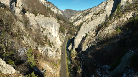 Coches-Circulando-Por-La-Carretera-En-Las-Gargantas-Del-Jura-En-Moutier-En-Suiza-No-Hay-Un-Frío-Y-Soleado-Día-De-Otoño-Con-Nieve-En-Las-Sombras