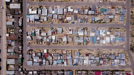 Top-down-drone-flight-over-township---informal-or-makeshift-houses-built-on-soil