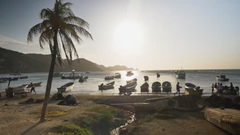 Sunset-in-a-beach-with-boats-and-a-palm-in-Santa-Marta,-Colombia