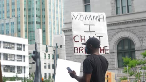 Black-man-holding-sign-that-reads-"Momma-I-Can't-Breathe"-in-Black-Lives-Matter-protest-for-George-Floyd
