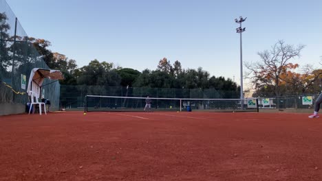Mann-Und-Mädchen-Spielen-Tennis-Im-Freien-Auf-Orangefarbenem-Tennisplatz