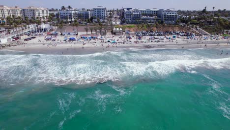Aerial-Video-Flying-Over-Water-Towards-Beach-in-Oceanside,-CA
