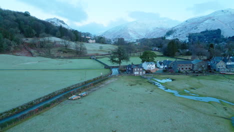 Frosty-fields-and-snowy-mountains-at-dawn-at-the-village-of-Grasmere