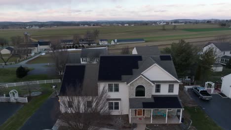 Aufsteigende-Luftaufnahme-Eines-Amerikanischen-Hauses-Mit-Sonnenkollektoren-Im-Winter