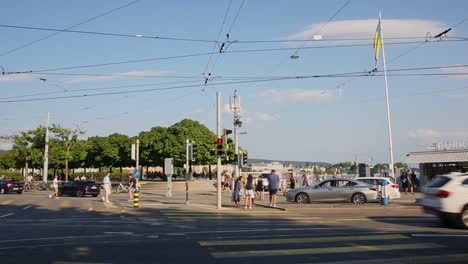 Zurich-busy-street-with-traffic-and-pedestrians-walking-by-harbour-in-sunlight